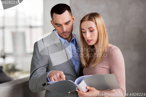 Image of businesswoman and businessman with folder