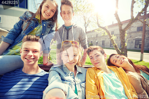 Image of happy teenage students or friends taking selfie