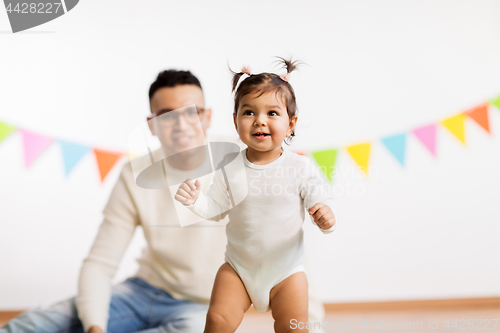 Image of happy father and little daughter at birthday party