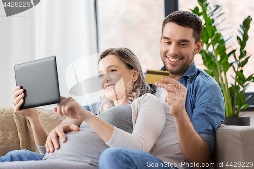 Image of man and pregnant wife shopping online at home