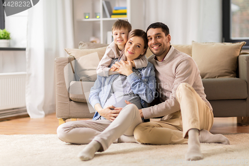 Image of happy family with pregnant mother at home