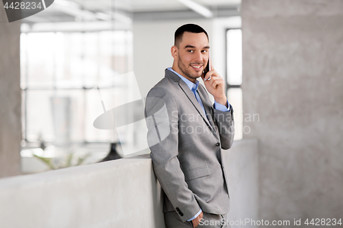 Image of businessman calling on smartphone at office