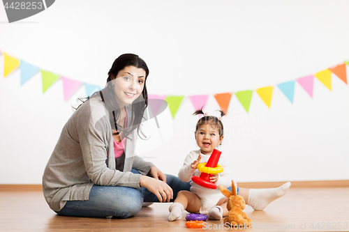 Image of mother and baby daughter playing with pyramid toy