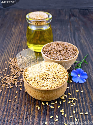 Image of Flaxen white and brown seed in bowl with oil on dark board