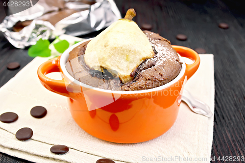 Image of Cake chocolate with pear in red bowl on towel