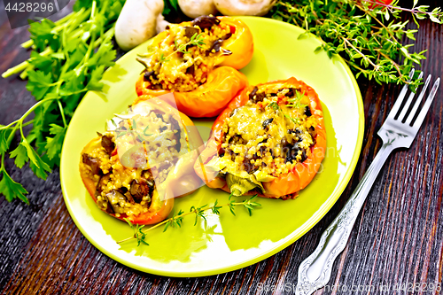 Image of Pepper stuffed with mushrooms and couscous in green plate on boa