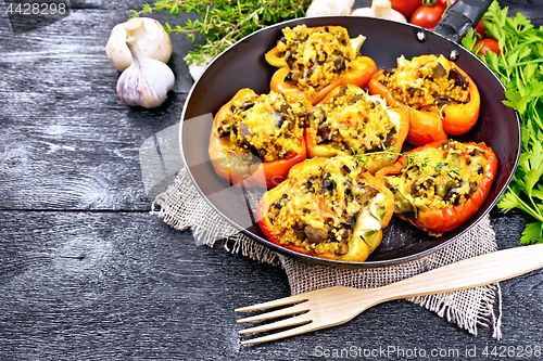 Image of Pepper stuffed with mushrooms and couscous in old pan on board