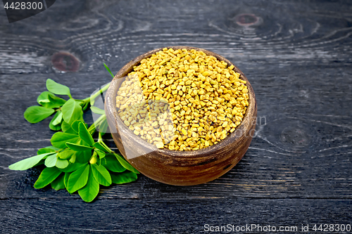 Image of Fenugreek with green leaf in clay bowl on black board