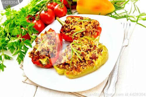 Image of Pepper stuffed with meat and couscous in white plate on table