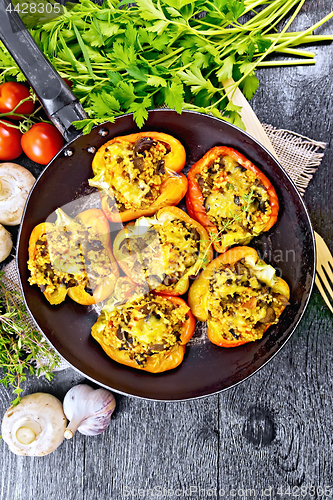 Image of Pepper stuffed with mushrooms and couscous in pan on board top