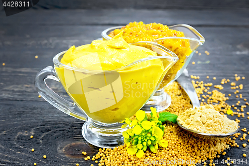 Image of Sauce mustard in two sauceboats with powder on black board