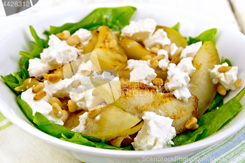 Image of Salad from pear and spinach with feta in dish on board