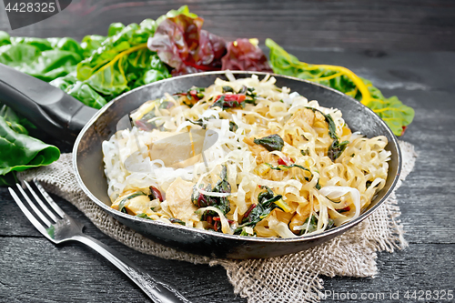 Image of Funchoza with chard and meat in pan on black board