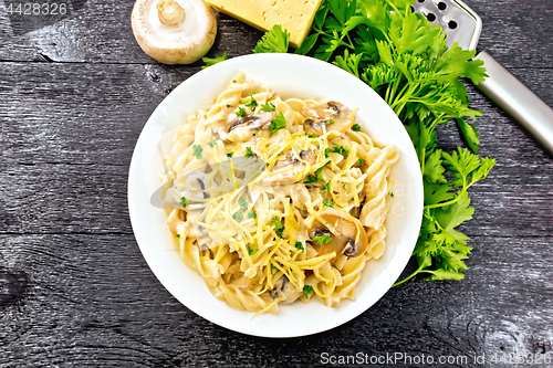 Image of Fusilli with mushrooms in plate on black board top