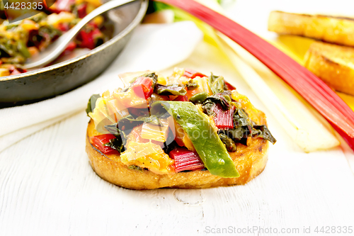 Image of Bruschetta with leafy beet and orange on table