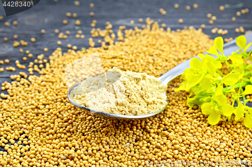 Image of Mustard powder in spoon with flower on board