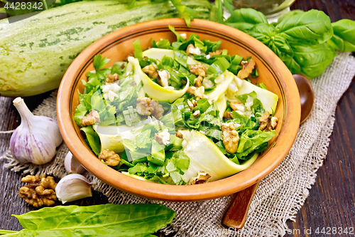 Image of Salad with squash and sorrel in clay plate on board