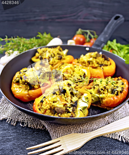 Image of Pepper stuffed with mushrooms and couscous in pan on burlap