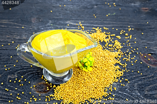 Image of Sauce mustard in sauceboat with flower on board