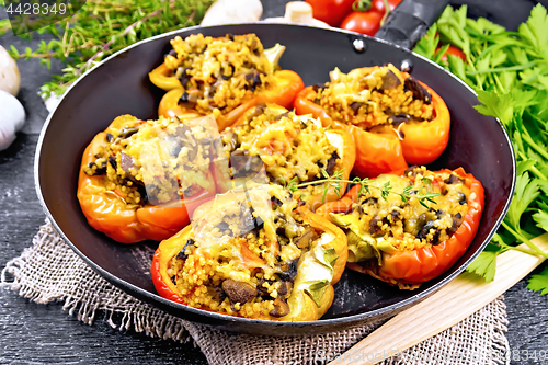 Image of Pepper stuffed with mushrooms and couscous in pan on black board