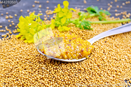 Image of Sauce mustard Dijon in spoon with flower on wooden board