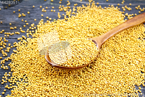 Image of Mustard seeds in spoon on board