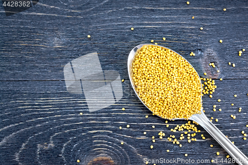 Image of Mustard seeds in metal spoon on board top