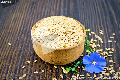 Image of Flaxen white seed in bowl with blue flower on board