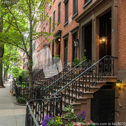 Image of Row of old brownstone buildings along an empty sidewalk block in the Greenwich Village neighborhood of Manhattan, New York City NYC