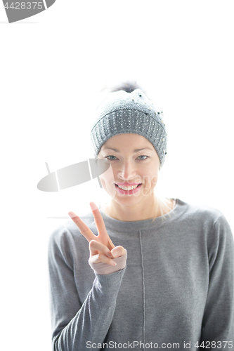 Image of Close up portrait of cheerful caucasian woman, gesturing peace sign and smiles