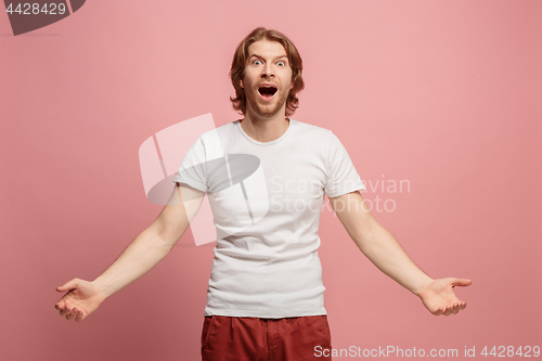 Image of The young attractive man looking suprised isolated on blue