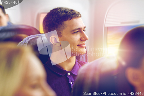 Image of happy young man travelling by plane