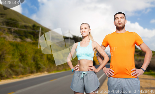 Image of happy couple doing sports over big sur hills