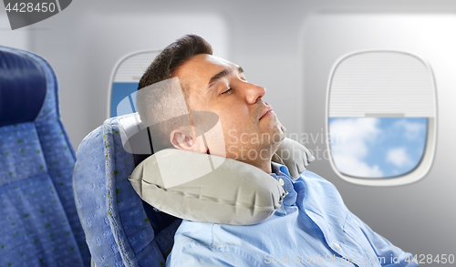Image of man sleeping in plane with cervical neck pillow
