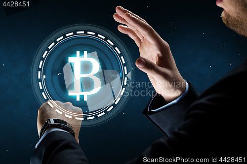 Image of businessman with smart watch and bitcoin hologram