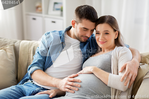 Image of man hugging pregnant woman at home