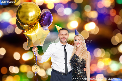 Image of happy couple with balloons over party lights