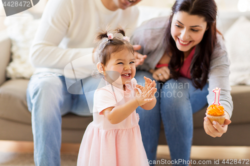 Image of baby girl with parents at home birthday party