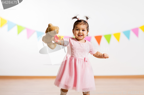 Image of happy baby girl with teddy bear on birthday party