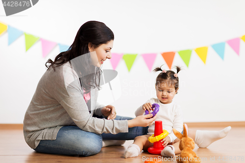 Image of mother and baby daughter playing with pyramid toy