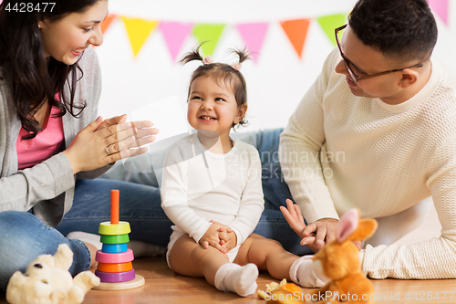 Image of baby girl with parents clapping hands