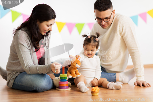 Image of baby girl with parents playing with toy rabbit