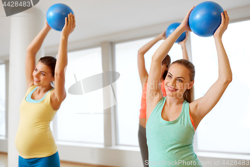 Image of pregnant women training with exercise balls in gym