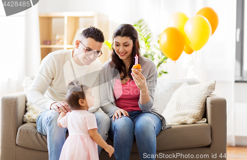 Image of baby girl with parents at home birthday party