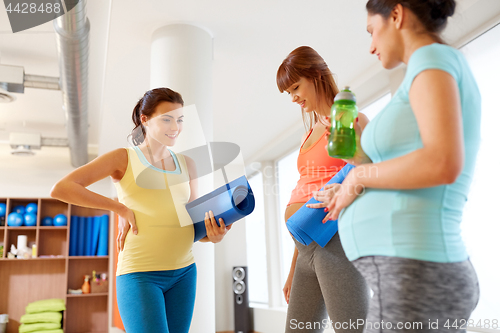 Image of pregnant women with sports equipment in gym