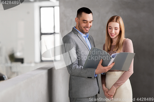 Image of businesswoman and businessman with folder