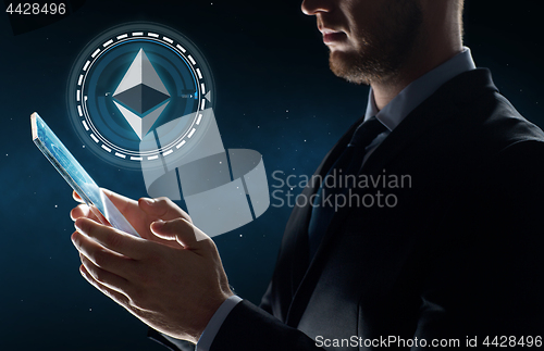 Image of businessman with tablet pc and ethereum hologram