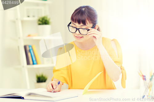 Image of happy asian young woman student learning at home