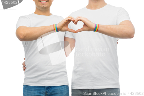 Image of couple with gay pride rainbow wristbands and heart