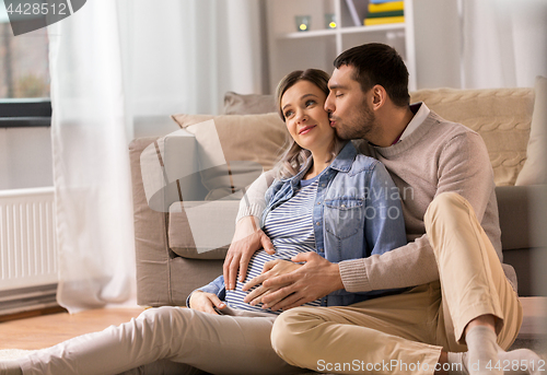 Image of man kissing and hugging pregnant woman at home